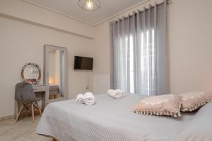 a white bedroom with a bed with towels on it at Pension Irene 1 in Naxos Chora