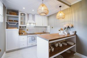 a kitchen with white cabinets and a wooden counter top at Apartment Lara in Senj