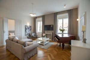 Una sala de estar con un sofá y un piano. en EL GUSTO HOMES Town, en Sopron