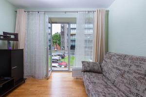 a living room with a couch and a large window at Amber apartment in Palanga