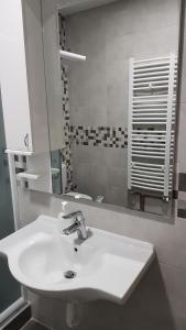 y baño con lavabo blanco y espejo. en Apartmani V&F, en Vrnjačka Banja