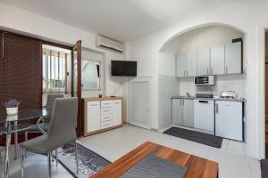 eine Küche mit weißen Schränken, einem Tisch und einem Esszimmer in der Unterkunft Apartments Smaila 1729 in Pula