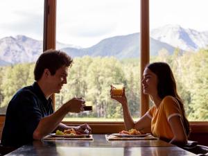 un hombre y una mujer sentados en una mesa con bebidas en Black Cat Guest Ranch, en Brule Mines