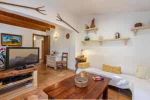 un soggiorno con divano bianco e TV di Villa Sementer del Molinet By homevillas360 a Pollença