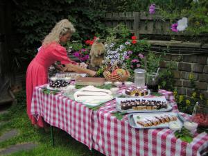 a woman standing at a picnic table with food at Hotel Mooserhof in Sesto