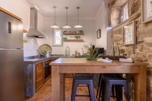 a kitchen with a wooden island with two stools at Casa da Mó - Douro in Armamar