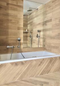 a bath tub in a bathroom with wooden walls at Hotel Abaco Altea in Altea