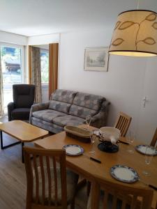 a living room with a table and a couch at Fortuna 404 in Leukerbad +6 photos