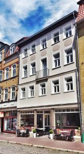 a large white building with tables in front of it at Appartements am Bachhaus in Eisenach