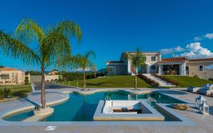 a villa with a swimming pool with palm trees at Villa Shangri-La Zakinthos in Zakynthos