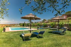 een groep stoelen en parasols naast een zwembad bij Podere n°8 Agriturismo in Maremma in Alberese