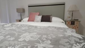 a bedroom with a bed with a gray and white blanket at CASA SIERRA in Alberite