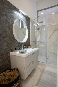 a bathroom with a sink and a mirror and a shower at EL GUSTO HOMES Town in Sopron