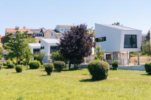 a house in a yard with bushes and trees at Wave Penthouses in Neusiedl am See