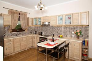 a kitchen with wooden cabinets and a table with chairs at G and A House in Póros Kefalonias