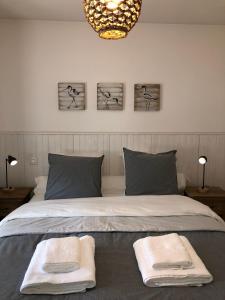 een slaapkamer met een bed met twee handdoeken erop bij Les terrasses ensoleillées de Carteret in Barneville-Carteret