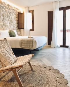 a bedroom with a bed and a chair and a rug at Hotel Abaco Altea in Altea
