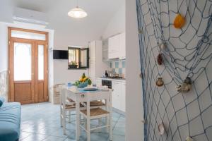 kuchnia z białym stołem i niebieskim w obiekcie ArmoNya Friendly House Amalficoast w mieście Tramonti