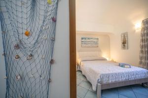 małą sypialnię z łóżkiem i siecią w obiekcie ArmoNya Friendly House Amalficoast w mieście Tramonti