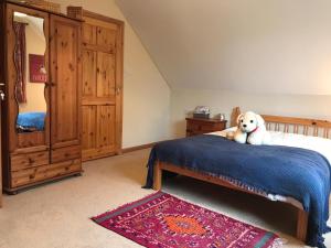 un perro sentado en una cama en un dormitorio en The Loft in Foxford, en Foxford