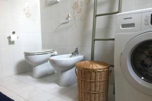 een badkamer met een toilet en een wasmachine bij Lake It Easy Mandello in Mandello del Lario