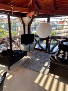 a living room with couches and a tv and windows at Sky Luxury Suite in Keszthely