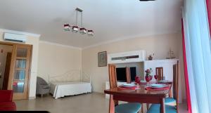 a living room with a table and a bedroom at Fantastic Fatima Apartment in Vila Real de Santo António