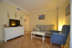 a living room with a couch and a tv at Apartamentos Solmares in Isla Canela