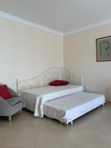 een slaapkamer met 2 bedden en een stoel bij Fantastic Fatima Apartment in Vila Real de Santo António