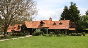una casa con techo rojo y patio en Gîte piscine jacuzzi privatisés Clos Valentin, en Freulleville