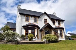 a white house with a black roof at The Meadows B&B in Moville