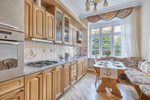 - une cuisine avec des placards en bois, une table et un canapé dans l'établissement Villa Deluxe Apartments, à Karlovy Vary