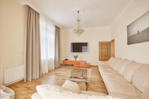 - un salon avec un canapé blanc et une table dans l'établissement Villa Deluxe Apartments, à Karlovy Vary