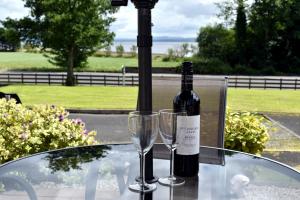 a bottle of wine and two glasses on a table at The Meadows B&B in Moville