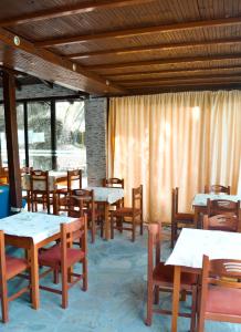 a dining room with tables and wooden chairs at Penny's Holiday Studio in Hanioti