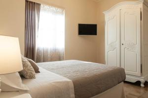 een slaapkamer met een wit bed en een raam bij Camera Vento Porto Antico La Cala in Palermo