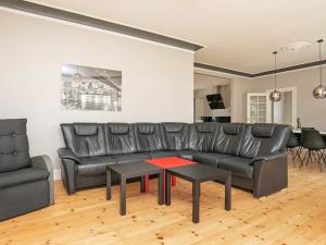 ein Wohnzimmer mit einem Ledersofa und einem Tisch in der Unterkunft 12 person holiday home in Nyborg in Nyborg