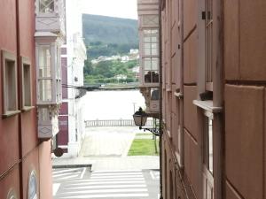 an alley between buildings with a view of a body of water at BERAMAR APARTMENT in Viveiro