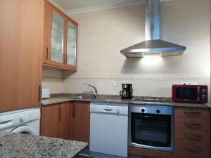 a kitchen with a sink and a stove top oven at BERAMAR APARTMENT in Viveiro +3 photos
