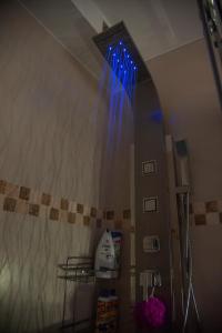 a bathroom with a shower with blue lights on the wall at Sensational view - Zemun in Belgrade