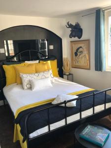 ein Schlafzimmer mit einem großen schwarzen Bett mit gelben Kissen in der Unterkunft Quai 17 Maison d'hôtes in Straßburg