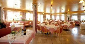 a dining room with white tables and chairs and tablesearcher at Hotel Waldheim in Natz-Schabs