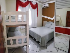a bedroom with two bunk beds and a mirror at Casa Oliveira 2 in Penha