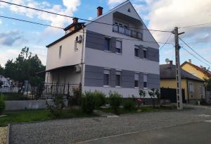 a white building on the side of a street at Emmabella Apartmanok Eger in Eger