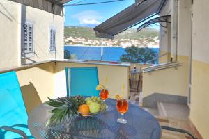 a table with a bowl of fruit on a balcony at Apartments Babin in Vinišće