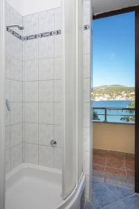 a bathroom with a shower with a view of the ocean at Apartments Babin in Vinišće +125 photos
