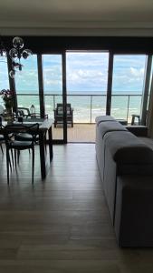 a living room with a couch and a table with a view of the ocean at Apart House by Gardenia in Dziwnów +3 photos