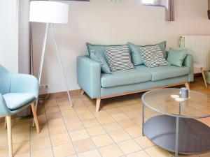 sala de estar con sofá azul y mesa en Charming house in Sint Jansrade with private pool and sauna, en Aubel