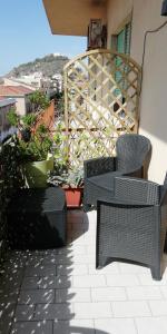 a patio with two chairs and a railing on a balcony at B&B del Centro in Capo dʼOrlando