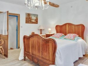 ein Schlafzimmer mit einem Holzbett und einem Kronleuchter in der Unterkunft Enticing Holiday Home in Viroinval near Forest in Le Mesnil